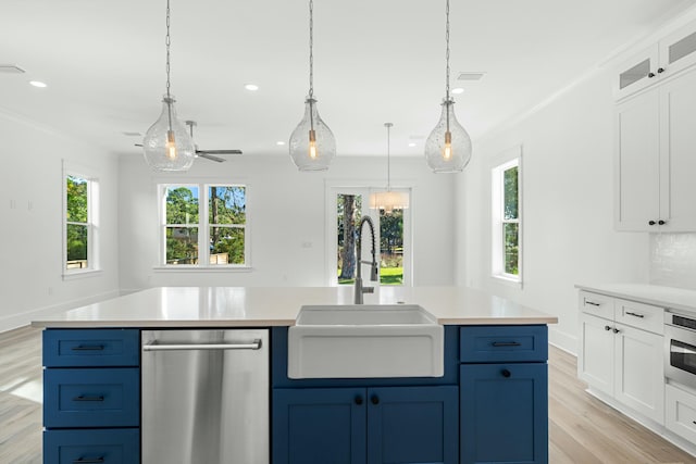 kitchen with white cabinets, decorative light fixtures, stainless steel dishwasher, and blue cabinetry