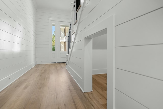 entryway featuring wooden walls and light hardwood / wood-style flooring