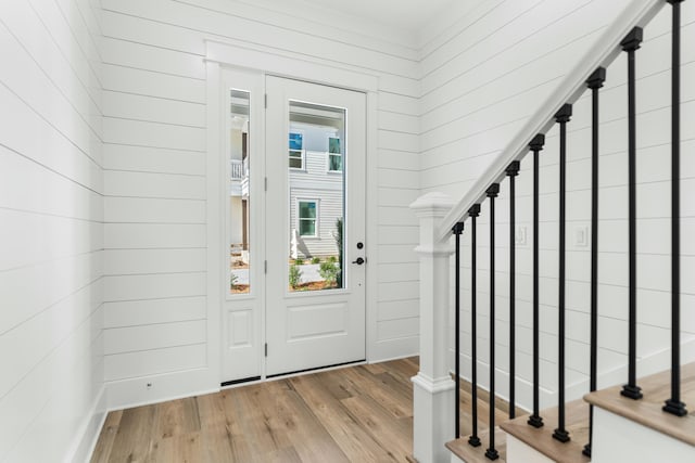 foyer featuring wooden walls and light hardwood / wood-style flooring