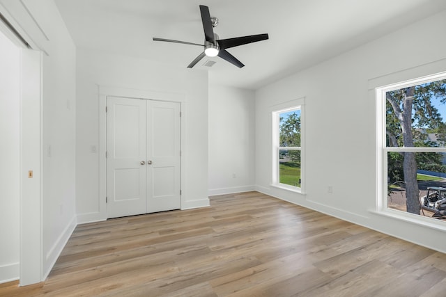 unfurnished bedroom with a closet, light hardwood / wood-style floors, and ceiling fan