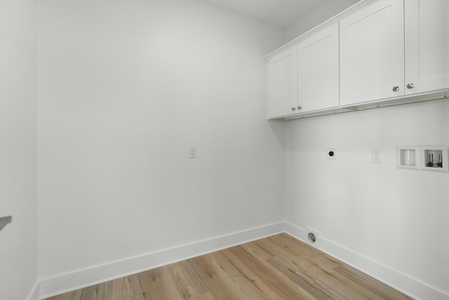 clothes washing area featuring electric dryer hookup, cabinets, light wood-type flooring, and hookup for a washing machine