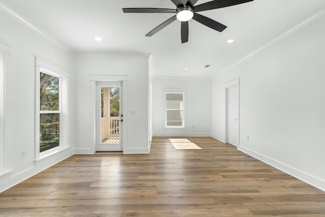 interior space with light hardwood / wood-style flooring, a healthy amount of sunlight, and ornamental molding