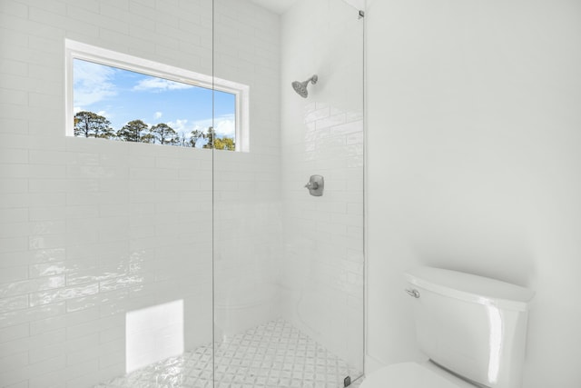 bathroom with tiled shower and toilet