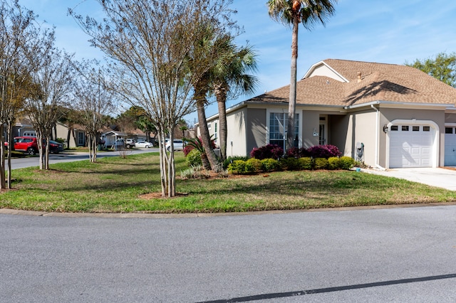 view of front of house featuring a garage and a front lawn