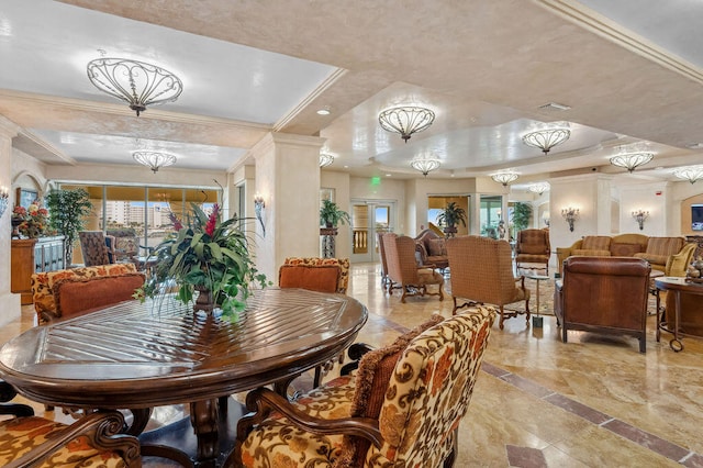 dining space with a raised ceiling, crown molding, and an inviting chandelier