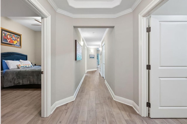 corridor featuring light wood-type flooring and crown molding