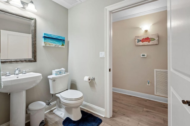 bathroom featuring wood-type flooring, toilet, and sink