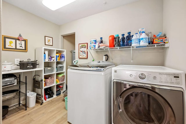 laundry area featuring light hardwood / wood-style flooring and washer and clothes dryer