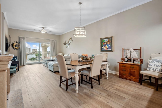 dining room with light hardwood / wood-style flooring, ceiling fan with notable chandelier, and ornamental molding