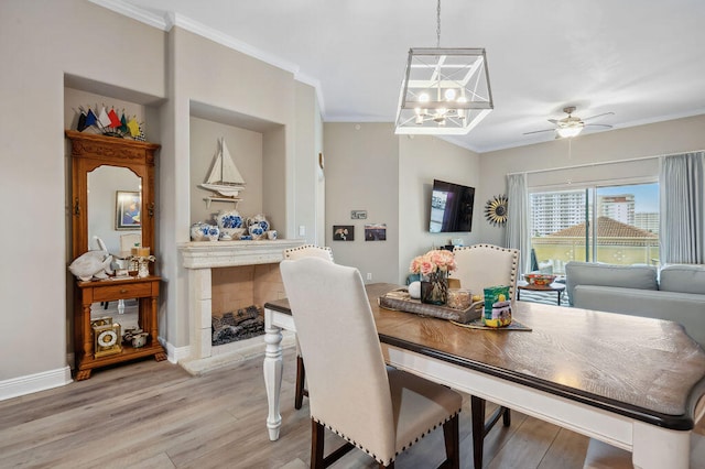 dining room with a tile fireplace, wood-type flooring, and ornamental molding