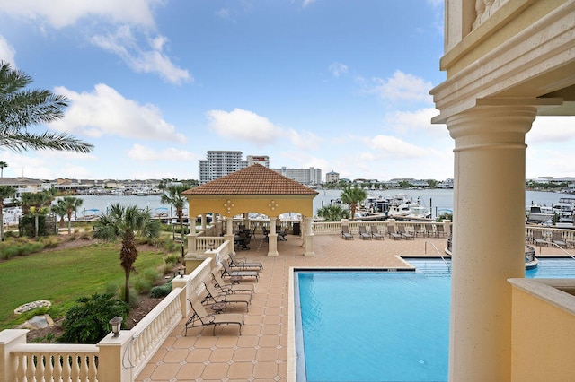 view of pool with a water view and a patio area