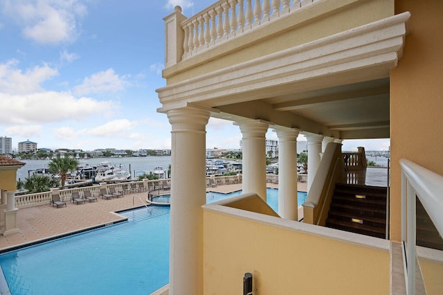 view of pool with a patio area and a water view