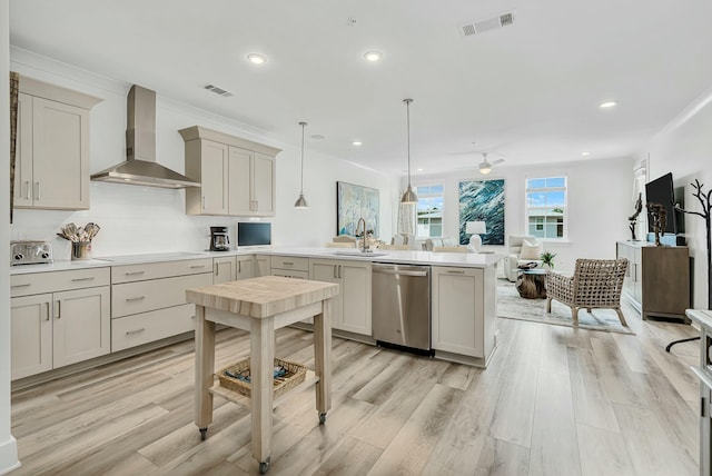 kitchen with stainless steel dishwasher, wall chimney exhaust hood, ceiling fan, decorative light fixtures, and light hardwood / wood-style flooring