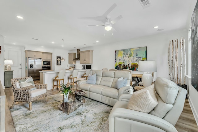 living room featuring light hardwood / wood-style floors and ceiling fan