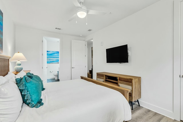 bedroom featuring ceiling fan, light wood-type flooring, and ensuite bath