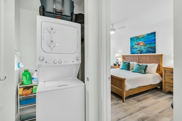 washroom with ceiling fan, stacked washer and dryer, and light hardwood / wood-style floors