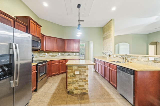 kitchen featuring sink, hanging light fixtures, kitchen peninsula, light tile patterned floors, and appliances with stainless steel finishes