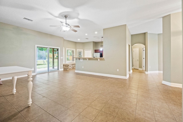 unfurnished living room featuring ceiling fan and light tile patterned flooring