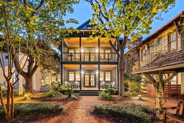 rear view of property featuring a balcony and french doors