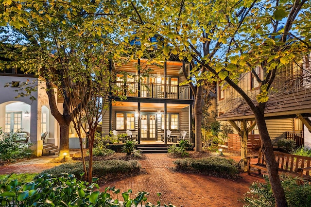 rear view of property with a balcony and french doors