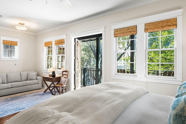 bedroom with wood-type flooring, ornamental molding, access to outside, and multiple windows