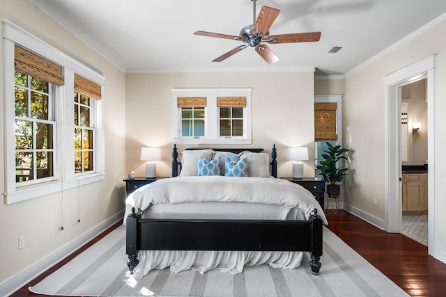 bedroom with ceiling fan, dark hardwood / wood-style flooring, ornamental molding, and connected bathroom