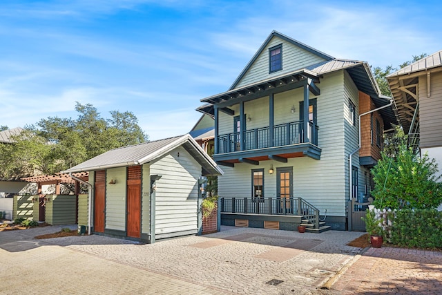 view of front facade featuring a balcony and a shed