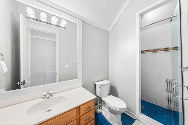 bathroom with vanity, tile patterned floors, crown molding, toilet, and tiled shower