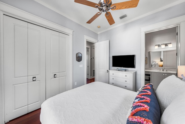 bedroom featuring dark wood-type flooring, sink, ensuite bath, ceiling fan, and a closet