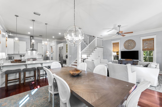 dining area featuring ceiling fan with notable chandelier, dark hardwood / wood-style flooring, ornamental molding, and sink