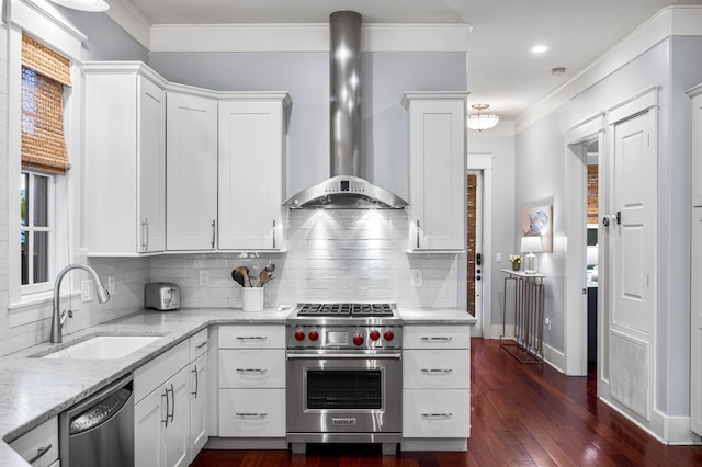 kitchen featuring dark wood-type flooring, white cabinets, sink, wall chimney exhaust hood, and appliances with stainless steel finishes