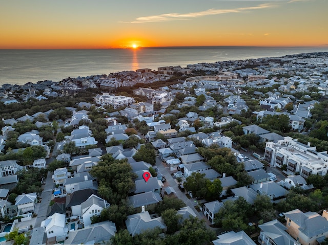 aerial view at dusk featuring a water view