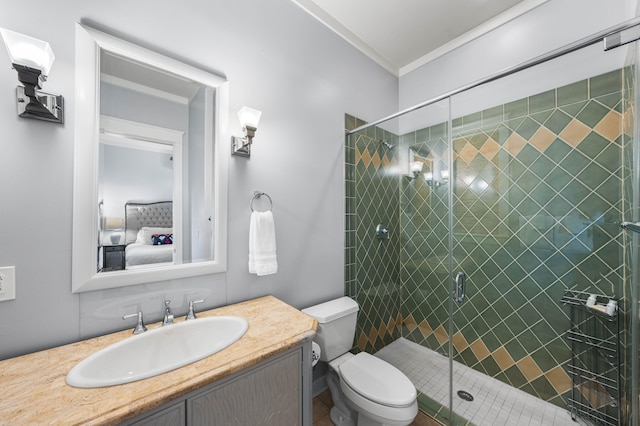 bathroom featuring tile patterned flooring, crown molding, toilet, vanity, and a shower with shower door