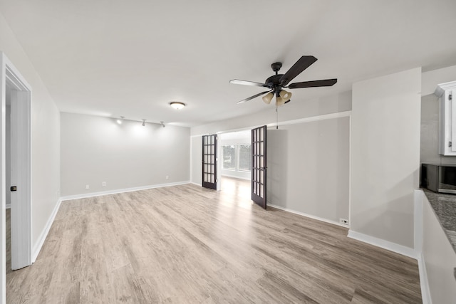 unfurnished living room featuring ceiling fan, light hardwood / wood-style flooring, track lighting, and french doors