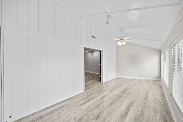 interior space featuring lofted ceiling, wooden walls, light hardwood / wood-style flooring, ceiling fan, and ornamental molding