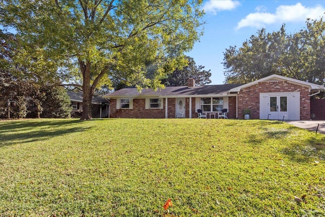 view of front of house featuring a front yard and french doors