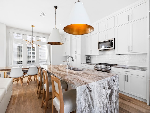 kitchen featuring appliances with stainless steel finishes, dark hardwood / wood-style flooring, white cabinetry, and sink