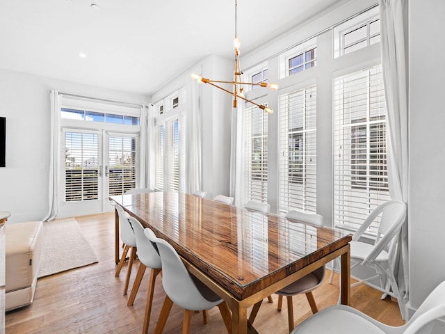 dining area featuring light hardwood / wood-style floors and a notable chandelier