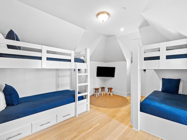 bedroom featuring wood-type flooring and vaulted ceiling