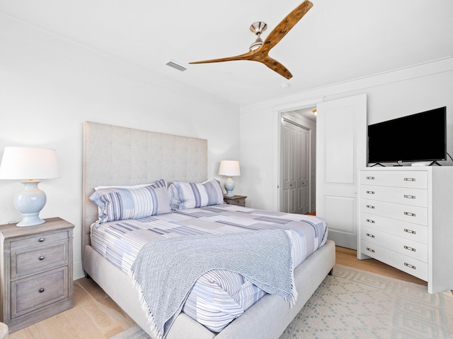 bedroom with ceiling fan, light hardwood / wood-style floors, and a closet