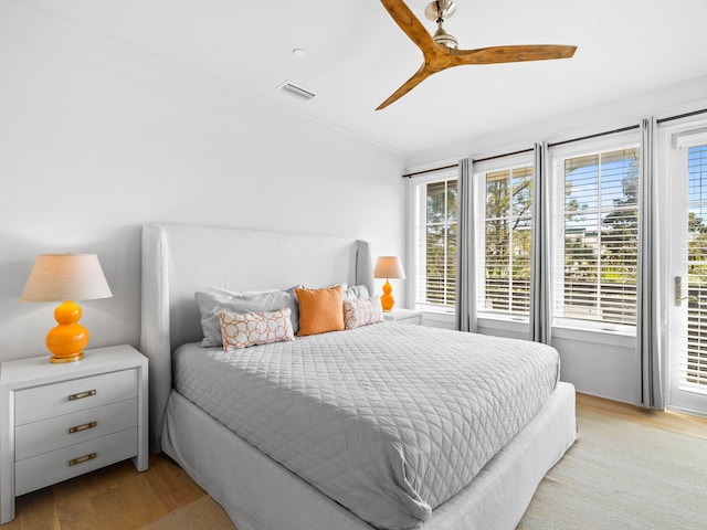 bedroom featuring ceiling fan, crown molding, and light wood-type flooring