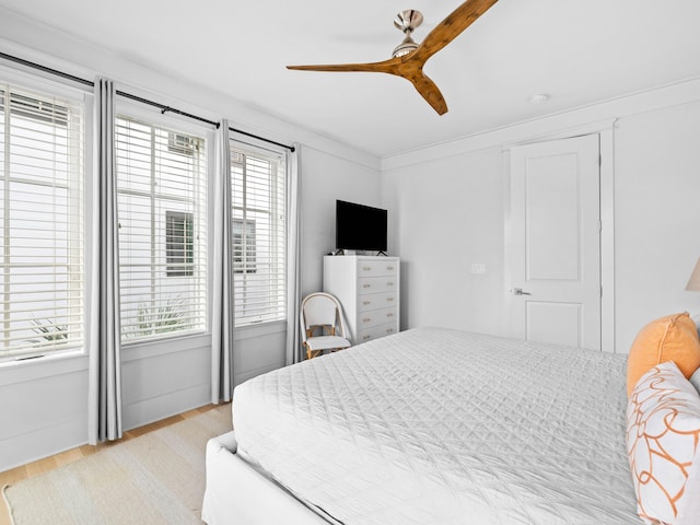 bedroom featuring ceiling fan, crown molding, and light hardwood / wood-style flooring