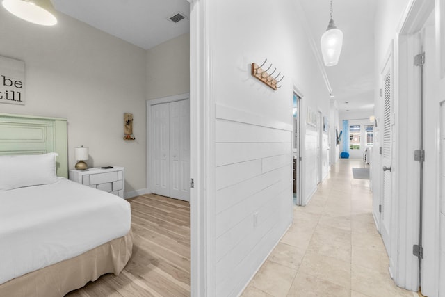 bedroom with light hardwood / wood-style floors and a closet