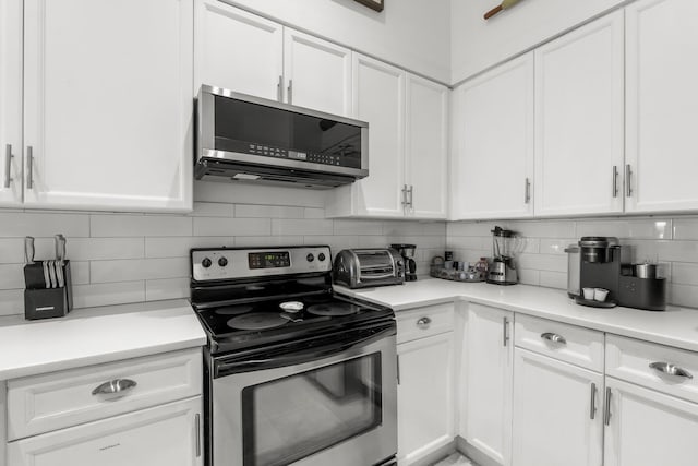 kitchen featuring tasteful backsplash, white cabinets, and appliances with stainless steel finishes