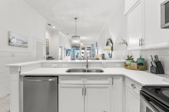 kitchen with white cabinets, sink, stainless steel appliances, and an inviting chandelier