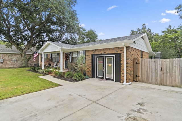 ranch-style home with covered porch and a front yard