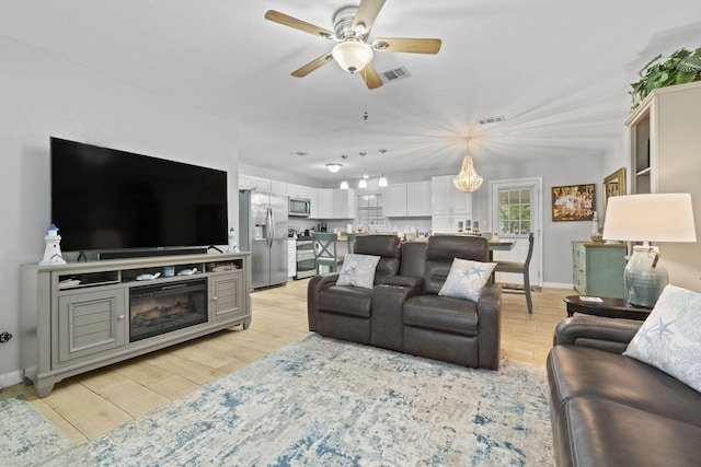 living room with light wood-type flooring and ceiling fan