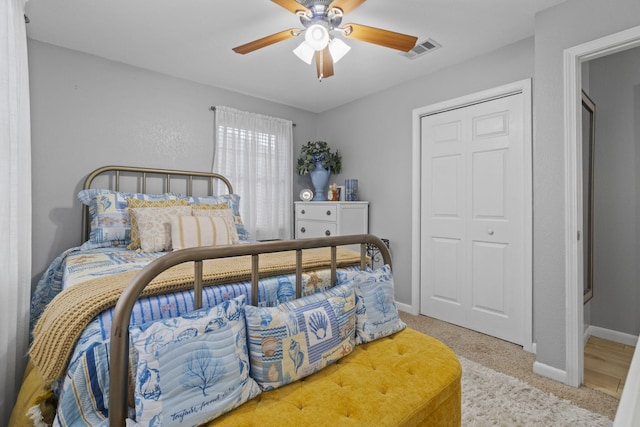 bedroom featuring ceiling fan, a closet, and light carpet