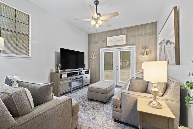 living room with french doors, ceiling fan, and wood walls