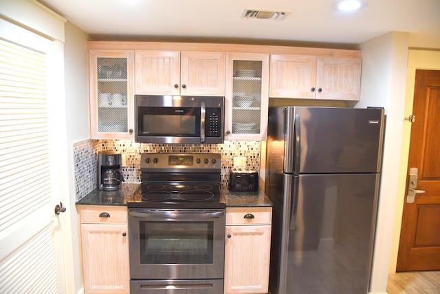 9200 Baytowne Wharf Blvd Unit 444/446, Miramar Beach, FL 32550 - kitchen featuring stainless steel appliances, glass insert cabinets, light brown cabinetry, and decorative backsplash